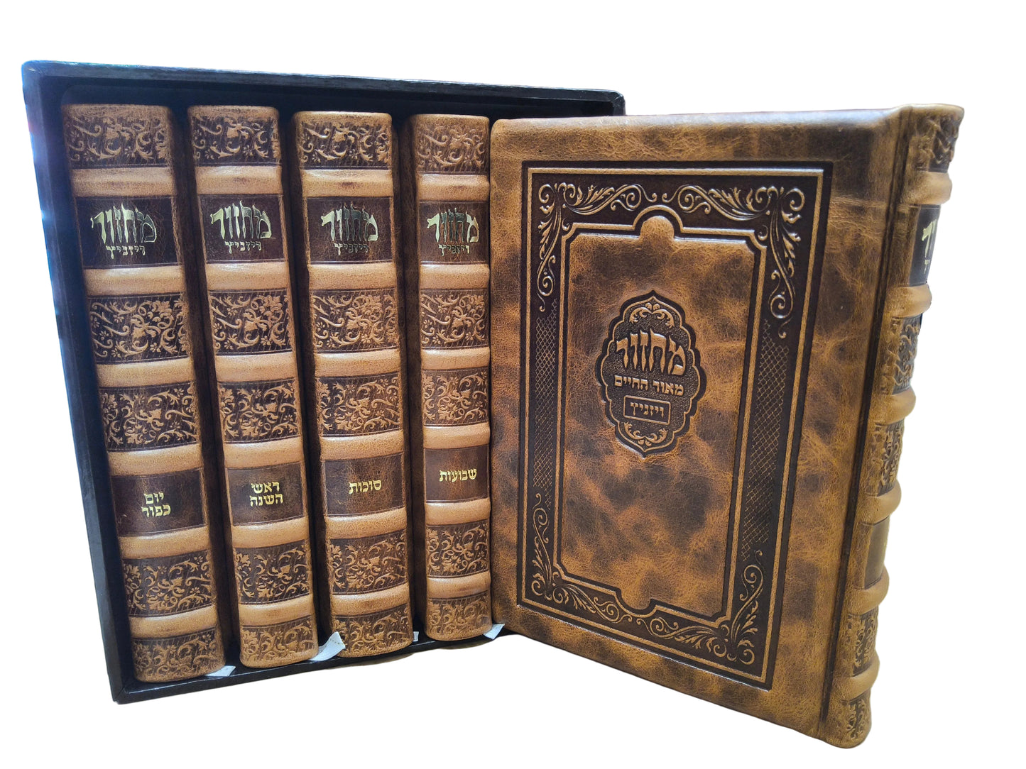 A set of ornate, antique-style leather-bound books displayed in a black presentation box on a wooden table, with bookshelves visible in the background.