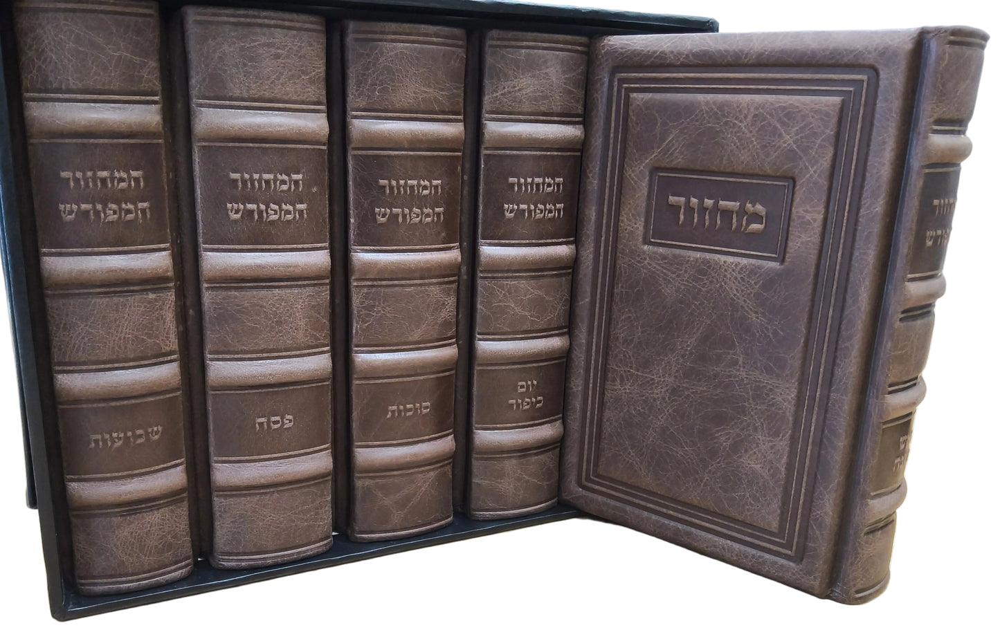 A set of five antique-style leather-bound books in a black presentation box, with one book open to show the cover. The books are dark brown with raised leather spines and Hebrew text, displayed on a light wood tabletop.