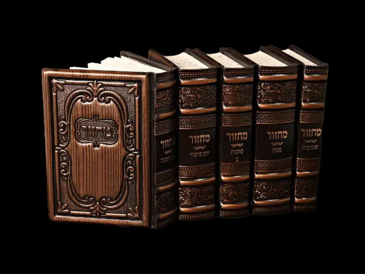 Set of five ornate leather-bound books on a dark background