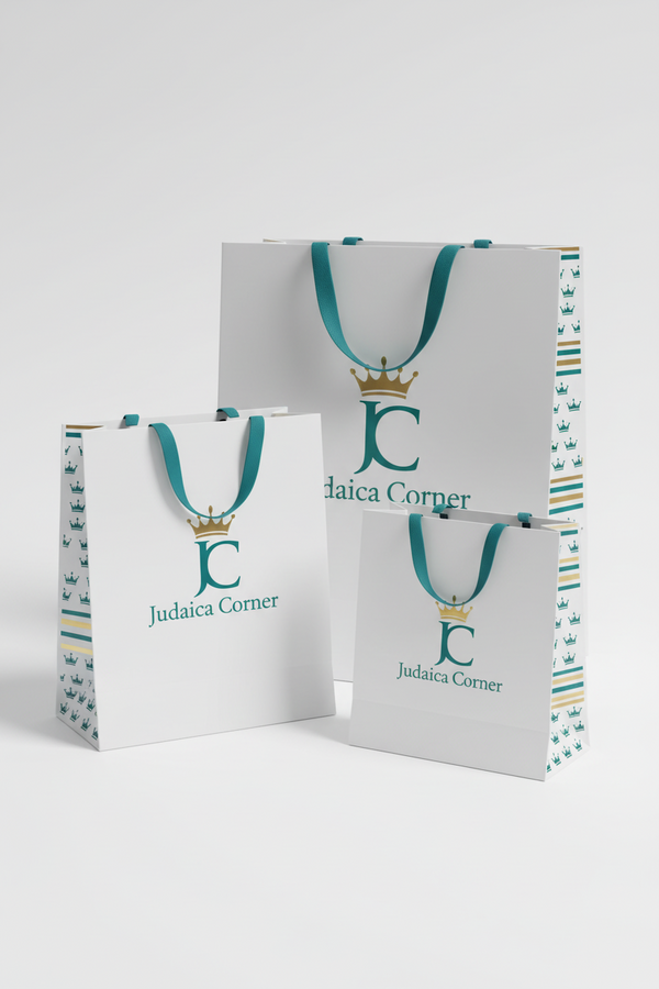 A coordinated set of branded gift bags, boxes, cards, and wrapping paper displayed on a clean white studio background. The items feature a white base with teal and orange printed branding, including a crown logo and the text 'daica corner' and Hebrew text.